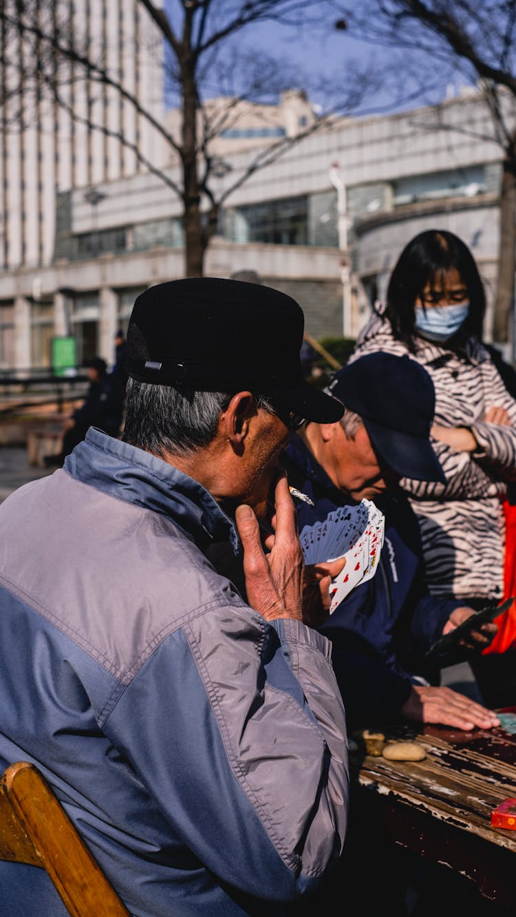 Elderly Men Praying Cards In A Park