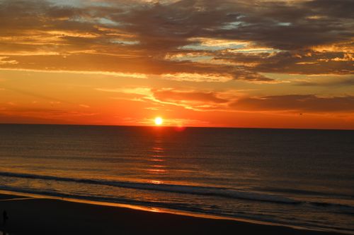 Free Beautiful sunset view with vivid colors over a calm ocean shore. Stock Photo