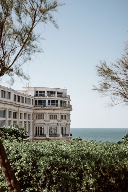 Classic architecture by the ocean in Biarritz, France, basking in bright sunlight.