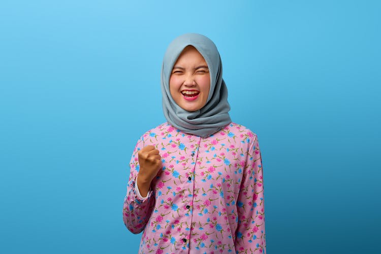 Portrait Of An Excited Woman Wearing Blue Hijab