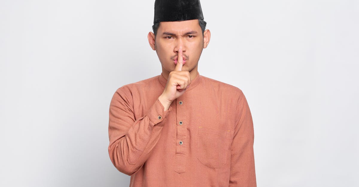 A Man Wearing Orange Long Sleeve and Black Hat Doing a Hand Sign · Free ...