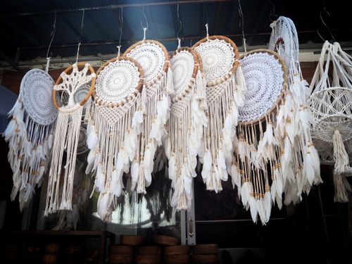 Free Close-up of handcrafted dreamcatchers hanging in a market setting, showcasing intricate designs. Stock Photo