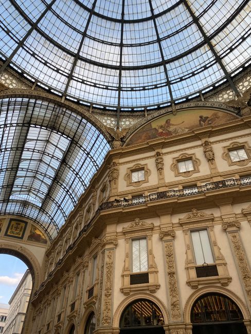 Intricate view of Galleria Vittorio Emanuele II, showcasing its elegant glass dome and detailed facade in Milan, Italy.