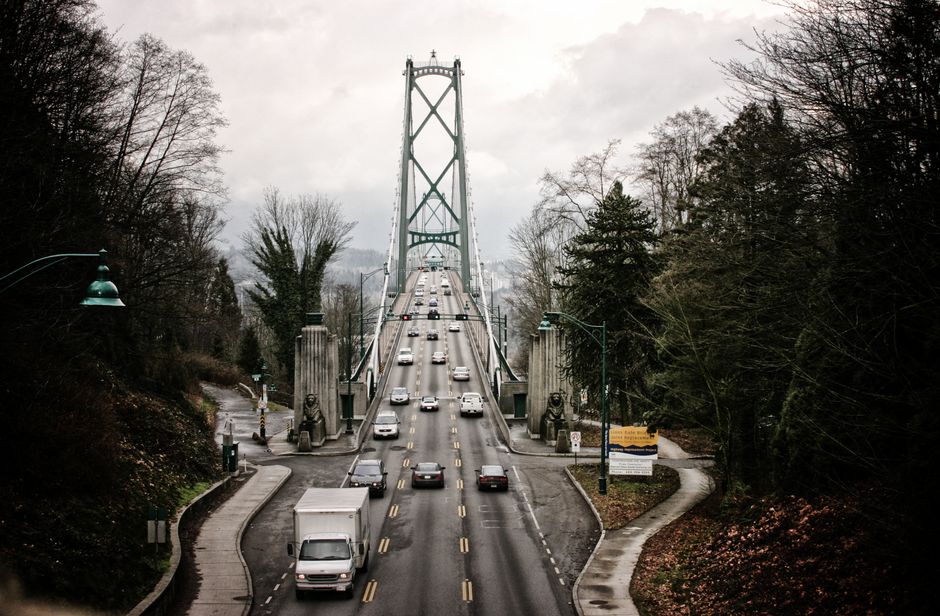 View of the Lions Gate Bridge in Vancouver on a cloudy autumn day with cars in motion.