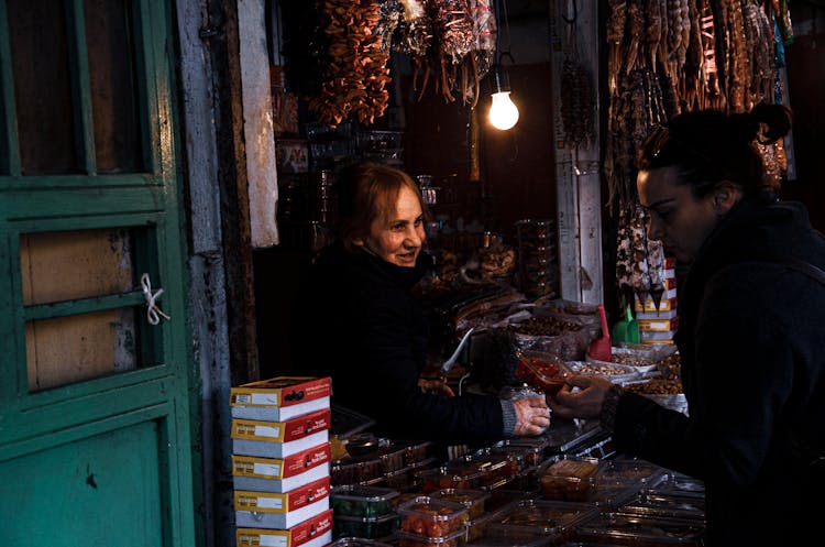 A Female Vendor Selling To A Customer