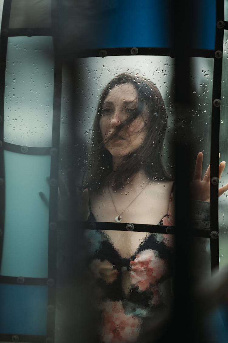 A Woman In Floral Dress Behind A Glass