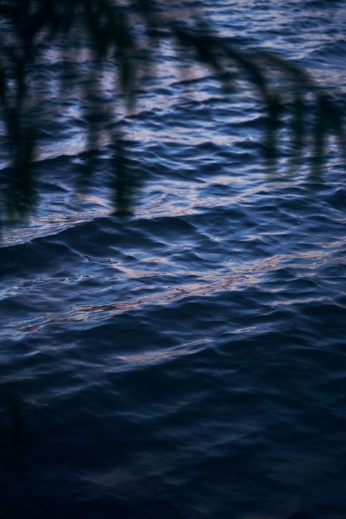 Free Gentle waves ripple across the ocean's surface at dusk, creating a serene and calming scene. Stock Photo
