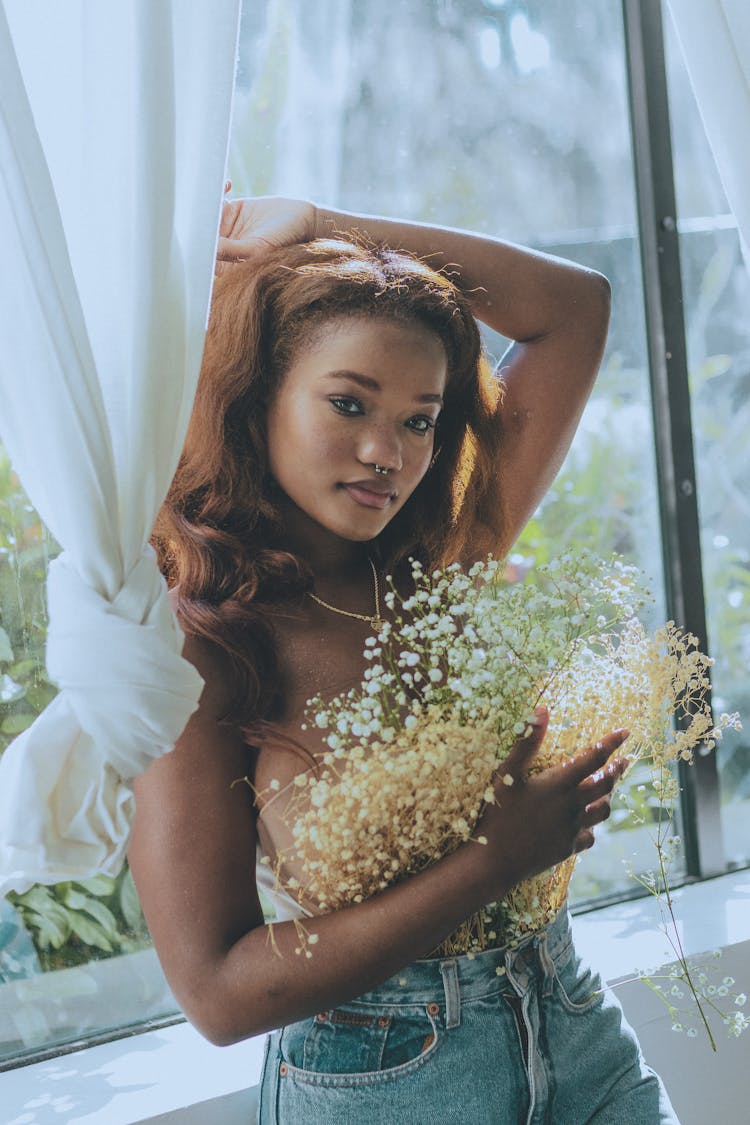 A Woman Posing While Holding A Bunch Of Baby's Breath Flowers 