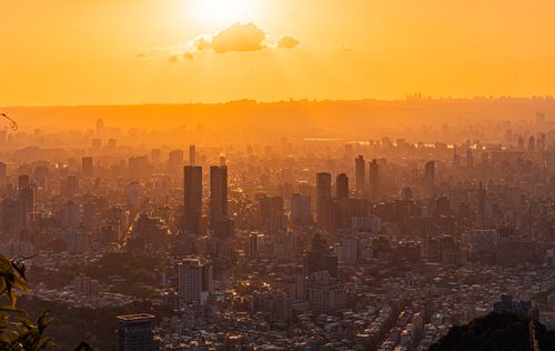 Free A stunning view of a cityscape with skyscrapers silhouetted against a vibrant sunset sky. Stock Photo