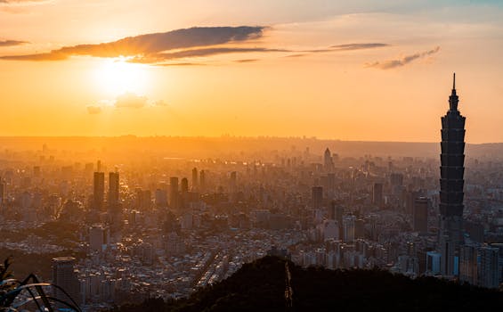 A breathtaking aerial view of Taipei city at sunset featuring the iconic Taipei 101 towering over the skyline.