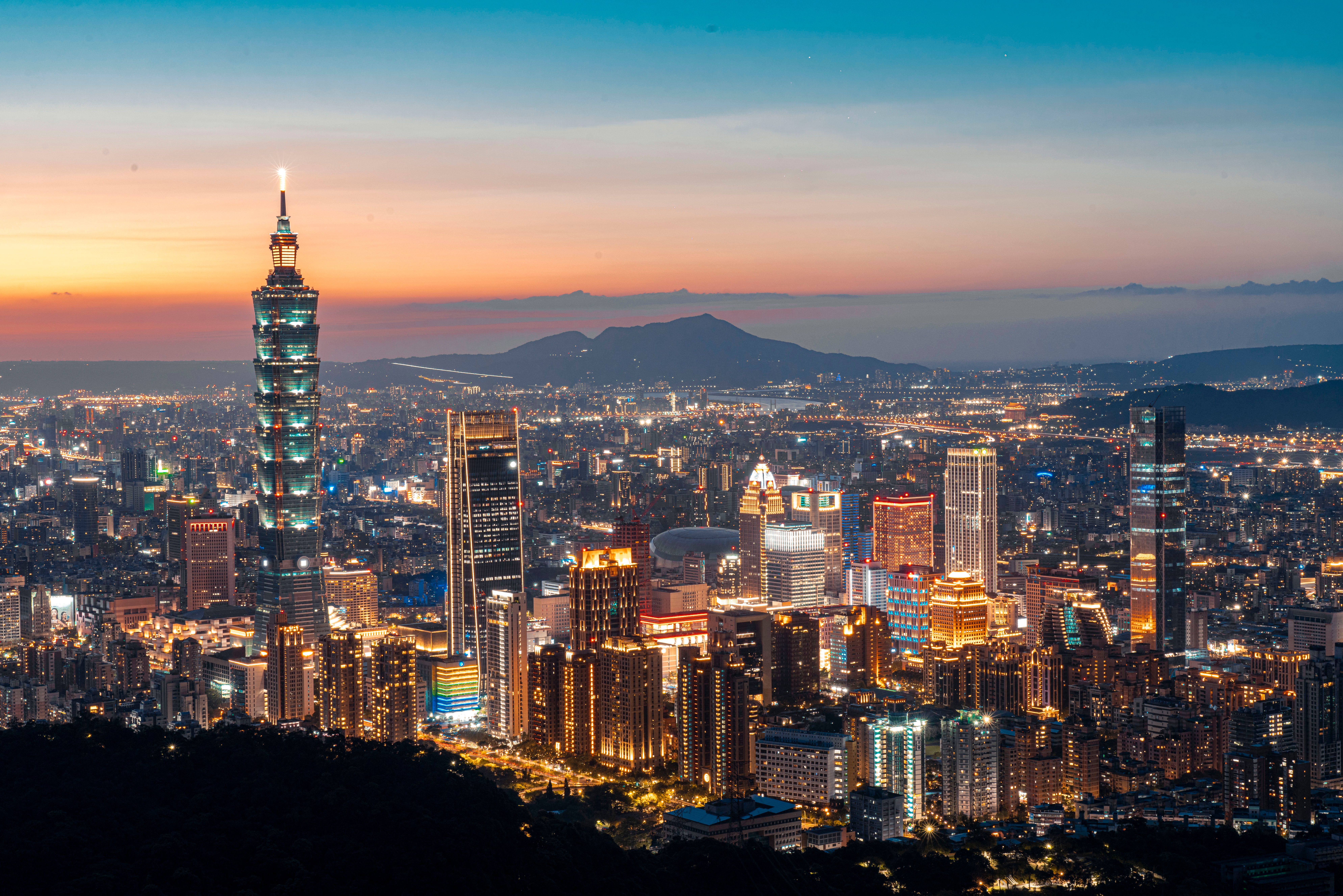A stunning view of Taipei's skyline at twilight, highlighting the iconic Taipei 101 and vibrant urban lights.