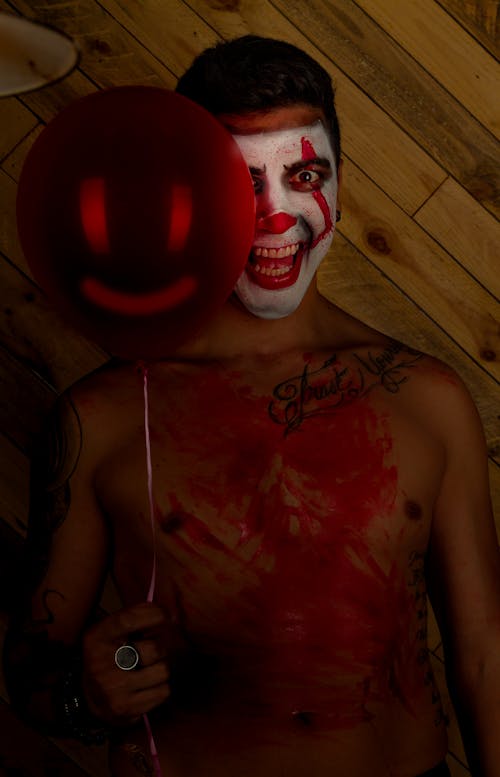 clown with scary smile holding a balloon