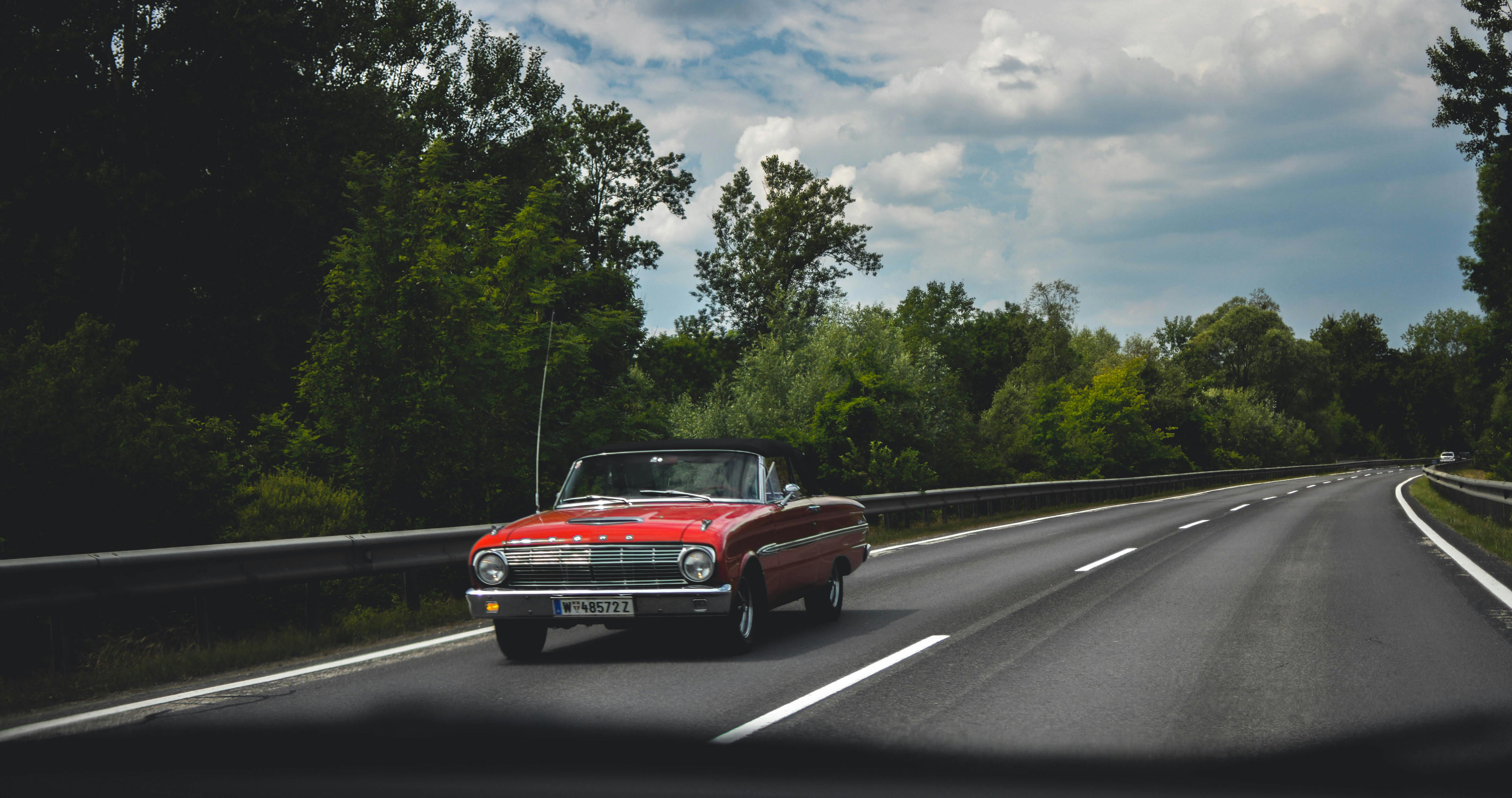 photography of red car on road