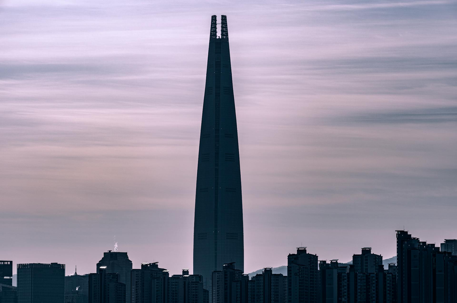 Silhouette of the Lotte World Tower in Seoul against a dusky sky, highlighting urban architecture.