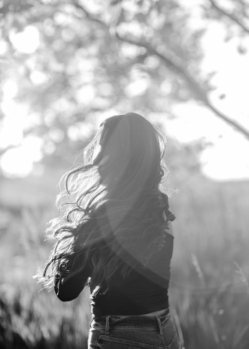 Free Elegant black and white portrait of a woman in nature with sunlit hair. Stock Photo
