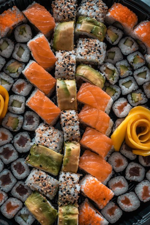 Free A beautifully arranged sushi platter featuring fresh salmon, avocado, and rolled sushi servings. Stock Photo