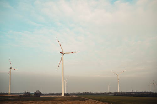 White Wind Turbines Under Cloudy Sky