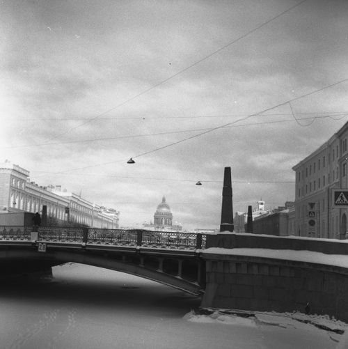 Free A serene black and white view of a city bridge in winter, a dome in the distance. Stock Photo
