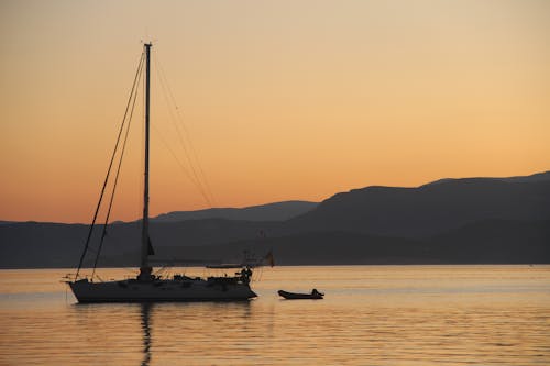 Free A Boat on Calm Sea during Sunset Stock Photo