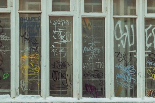 Free Urban graffiti art on glass windows with a snowy base, showcasing street culture and creativity. Stock Photo
