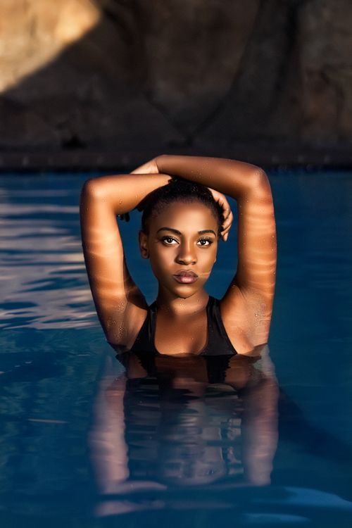 Free Stylish portrait of a woman in a swimsuit, illuminated by natural light in a pool setting, Johannesburg. Stock Photo