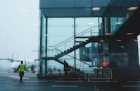 里加机场的雾中，乘客正在登机，展现了现代机场的建筑风貌