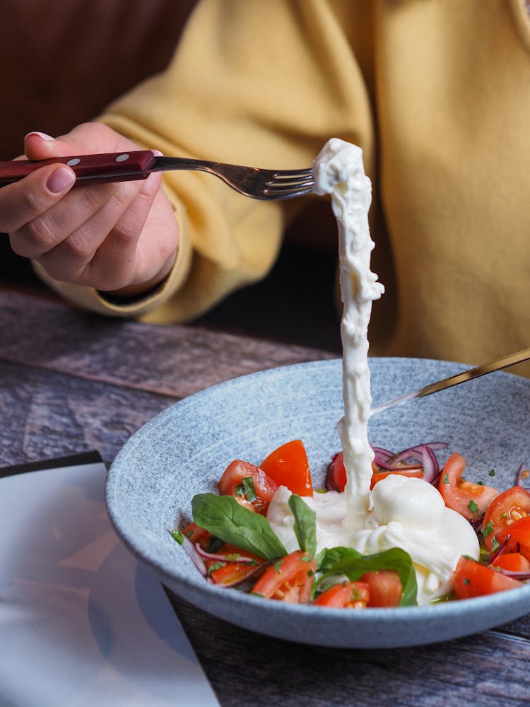 Person Eating Salad With Tomatoes