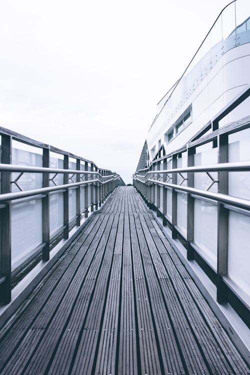 Photo of Brown Wooden Path Near White Building