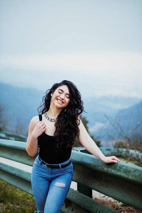 A Woman Wearing a Black Tank Top and Denim Pants