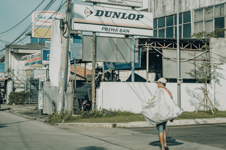 Man Carrying A Sack Crossing The Street