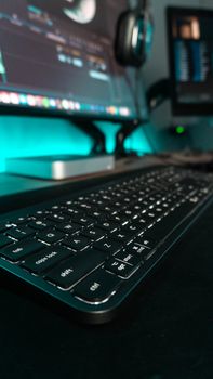 Close-up of a sleek keyboard in a contemporary workspace with dual monitors.