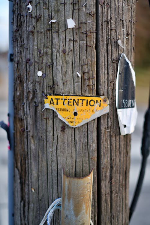 Torn Attention Sign on Wooden Post