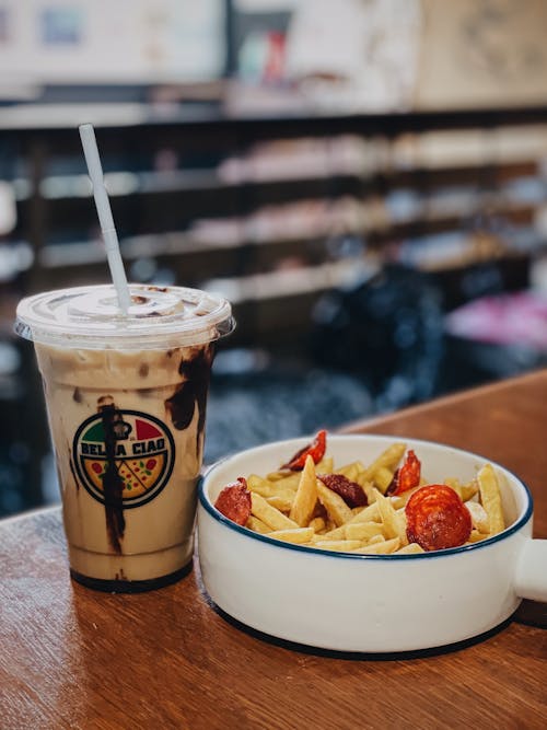 Chocolate Drink on Disposable Cup Beside Food on Bowl