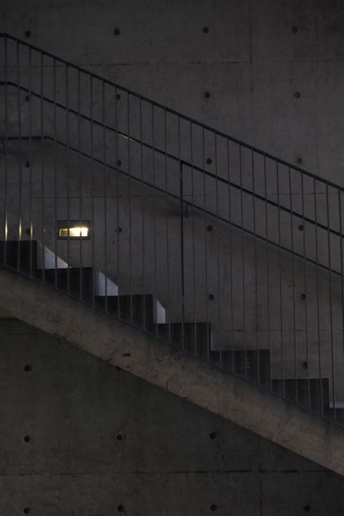 Free Side view of a concrete staircase with steel railing in a modern architectural setting at dusk. Stock Photo