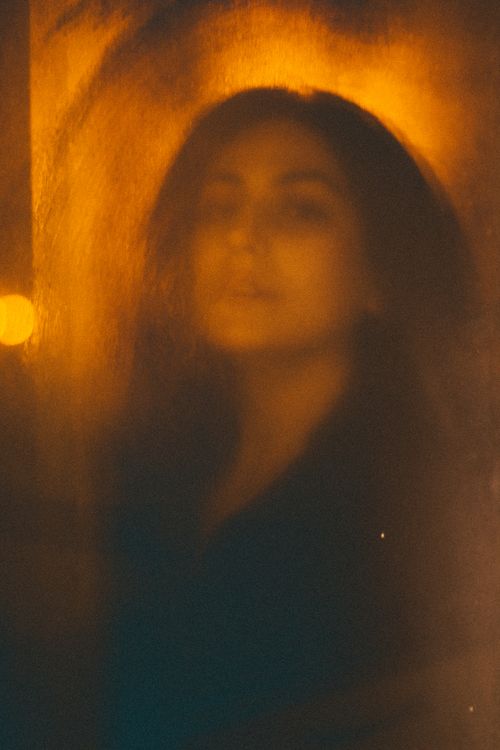 Free A blurred and artistic portrait of a woman in warm, glowing light. Stock Photo