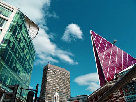 从低角度仰望现代摩天大楼，玻璃外墙映衬着清澈的蓝天