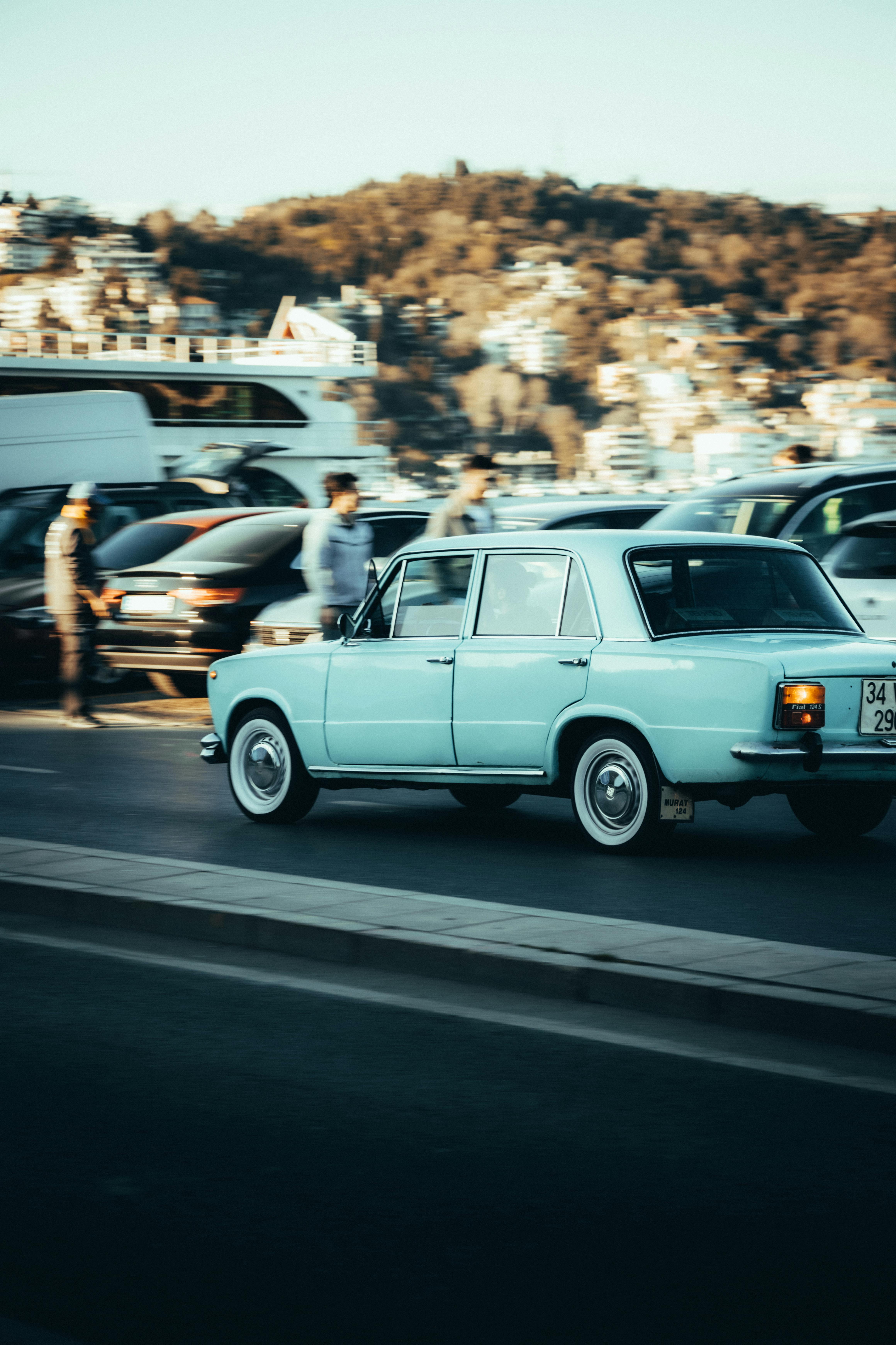 vintage car driving on road nearby town