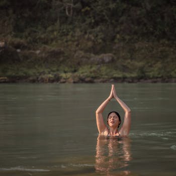 A woman practices yoga in the tranquil waters of the Ganges River in Rishikesh, India.