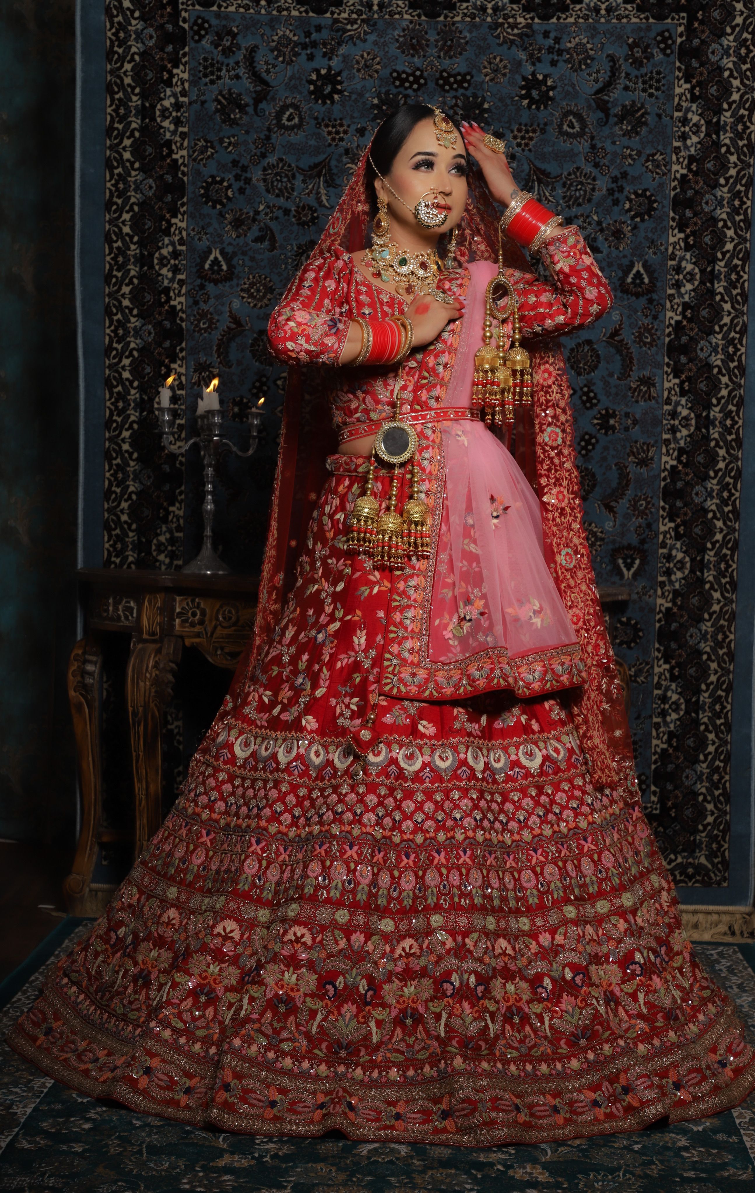 Stunning Indian bride in red lehenga with intricate embroidery and jewelry, New Delhi location.
