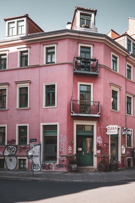 Explore this picturesque pink corner building with balconies in Dresden's urban landscape.