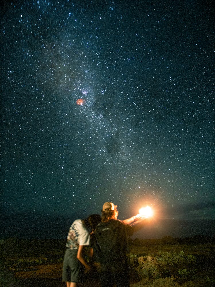 Couple Admiring View Of Milky Way In Night Sky