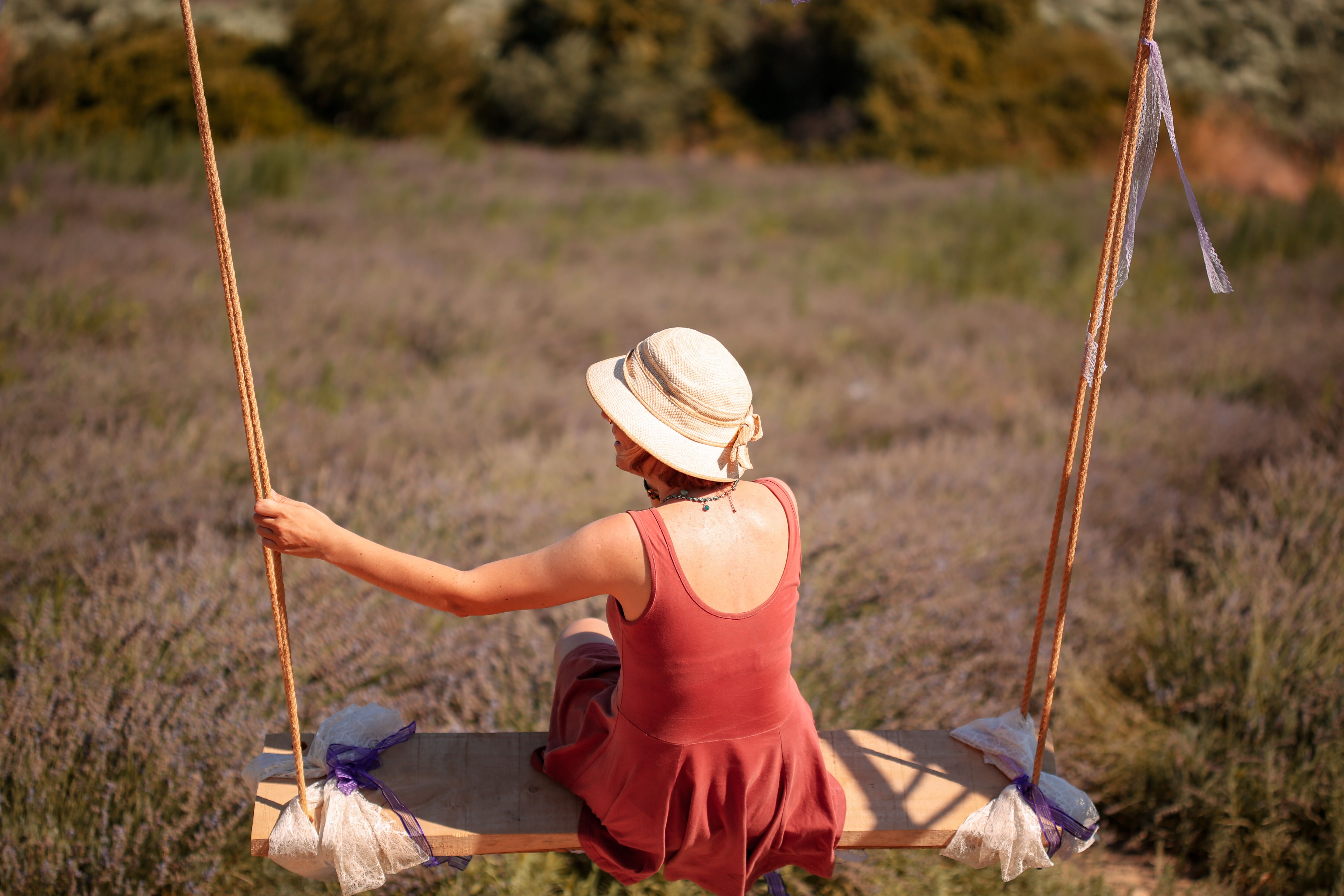 A woman in a red dress swings in a lavender field in Turgut, İzmir, Turkey.