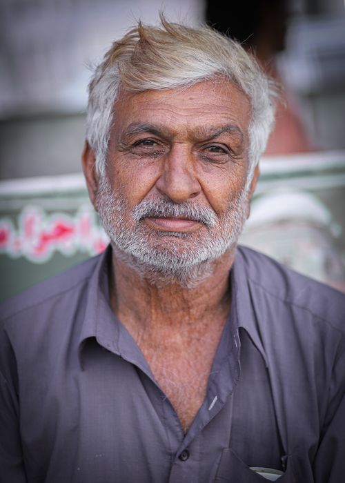 Free Closeup portrait of a senior man with white hair and beard in a gray shirt, expressing deep thought. Stock Photo