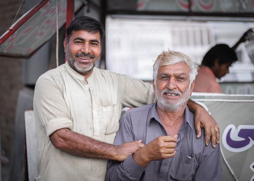 Free Two men smile warmly in an outdoor setting, capturing a candid and joyful moment. Stock Photo