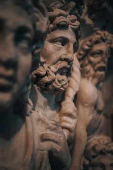 Close-up of ancient marble sculpture depicting mythological figures on exhibit in a museum.