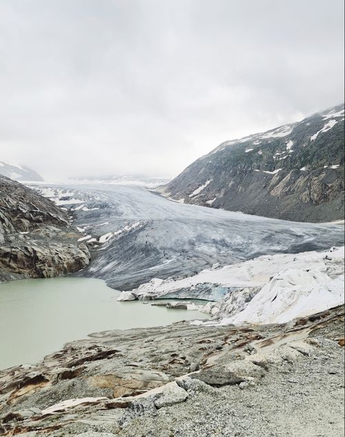 Free Stunning view of a vast glacier surrounded by rugged mountains and cloudy sky. Stock Photo