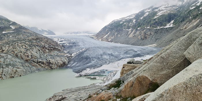 A stunning view of a glacier with a serene lake and rugged mountains, highlighting nature's beauty.