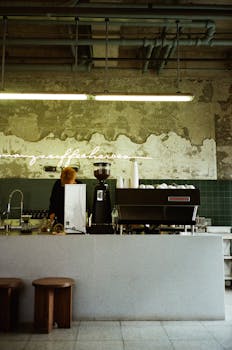 Retro-inspired coffee shop interior featuring a modern espresso machine and barista at work.