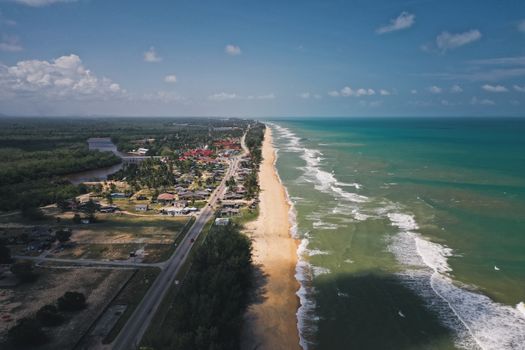 A breathtaking aerial shot capturing a coastal town and sandy beach along a vast shoreline.