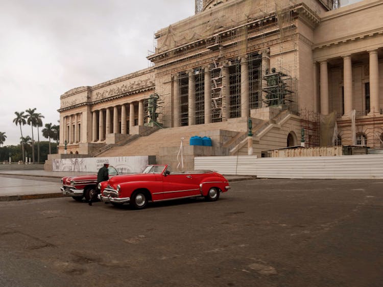 Capitol Building With Red Classical Car In Havana Cuba